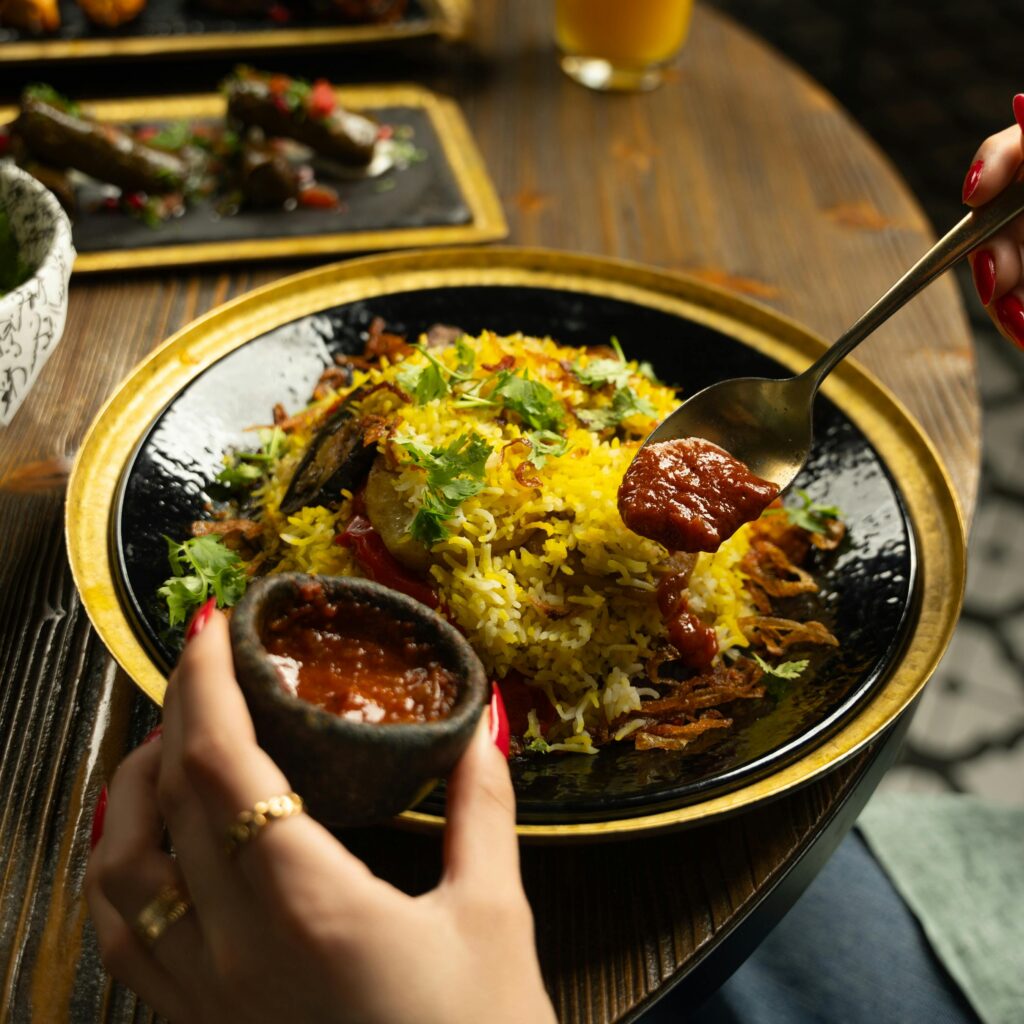 Close-up of traditional Indian rice dish with chutney on a rustic plate.