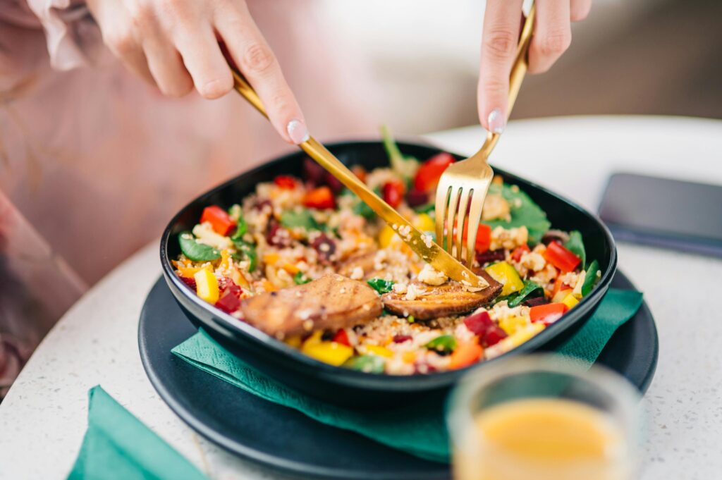Vibrant quinoa salad with fresh veggies being enjoyed by a diner.